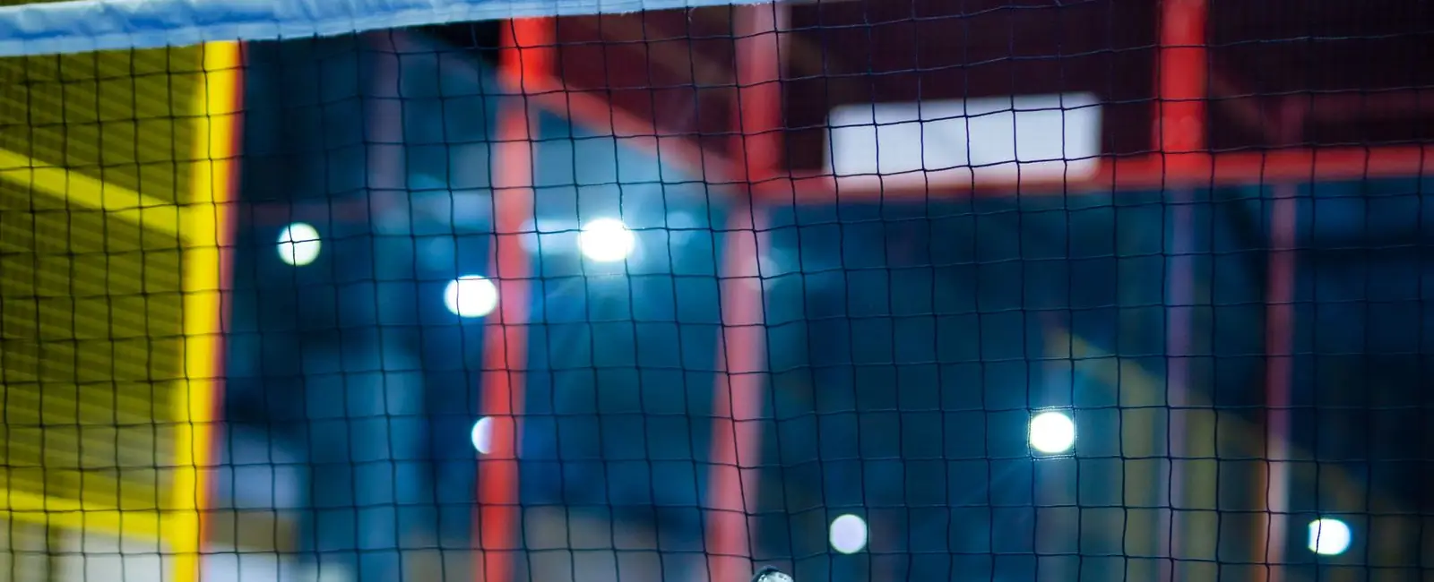 Raquette de padel et balle sur un terrain indoor